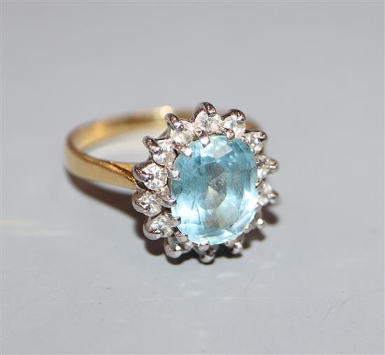 A modern 18ct gold, aquamarine and diamond set oval cluster dress ring, size M.